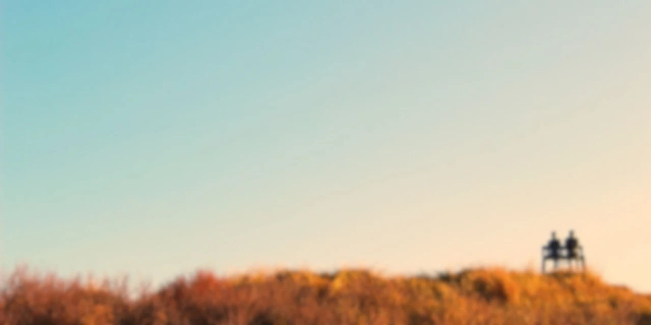 Two people watching the sunset over open landscape